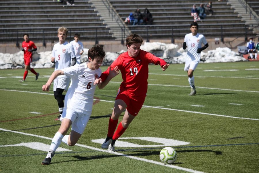 Battle for the ball. Senior Carson White(#19) fights a Smoky Hill defender for the ball.