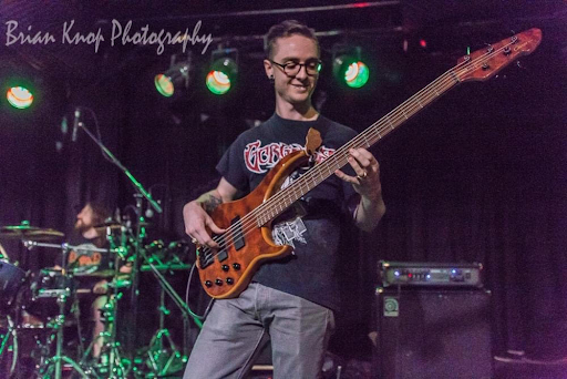 Geare plays electric bass at one of their shows by Brian Knor Photography.