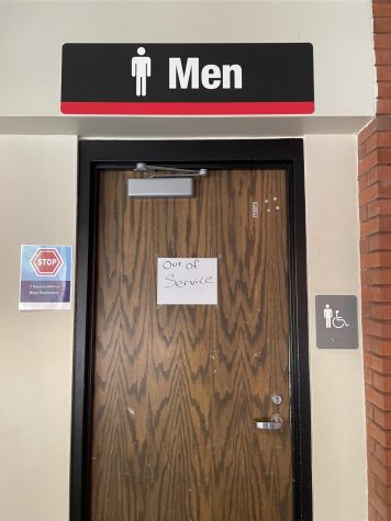 The East 100s men’s bathroom with a closed sign posted on the door. 
