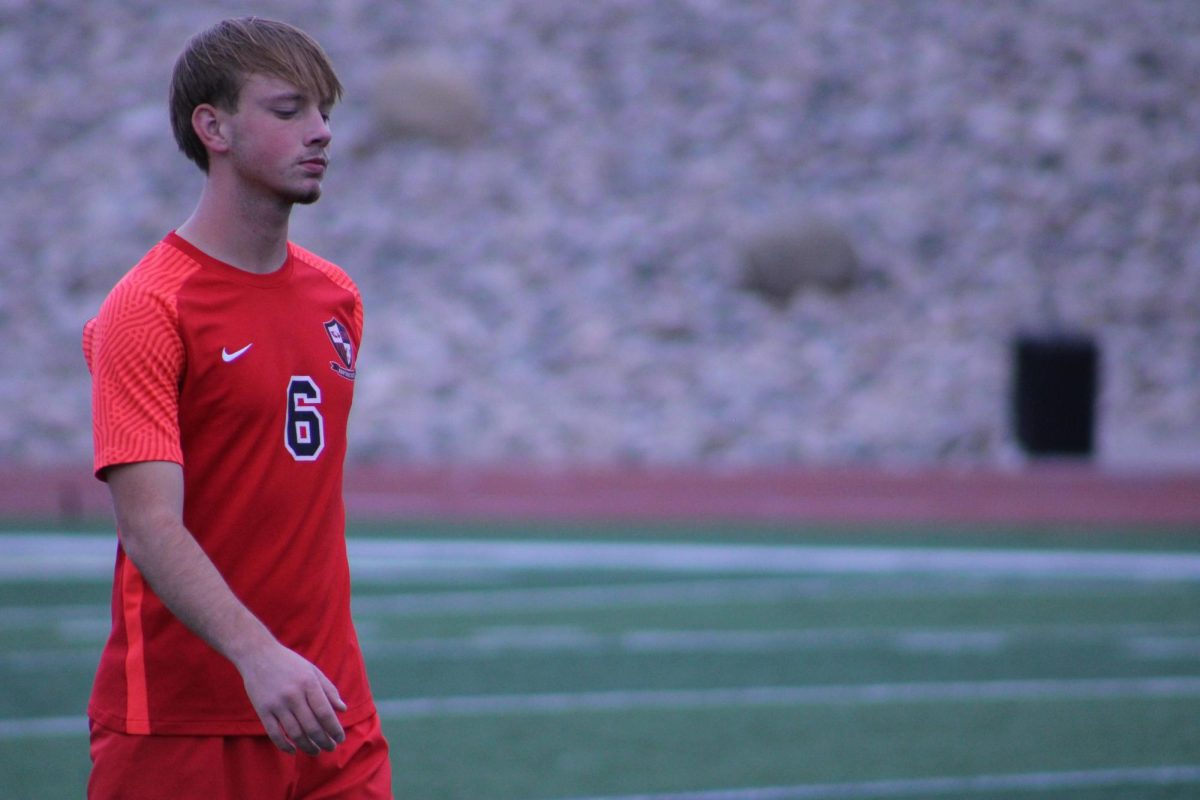 A close up of senior Ethan Robl walkin to assist Blair at the goal.