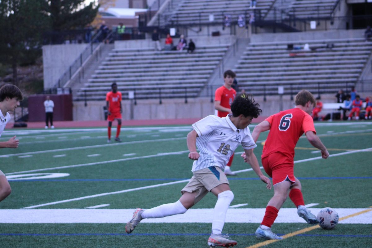 Senior Ethan Robl kicking the ball to one of his teammates.