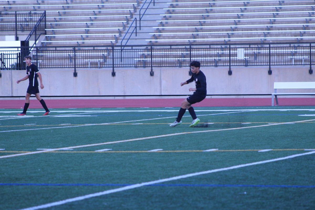 Senior Kyler Matya makes a long kick out to his teammates, with another senior, Gus Zilliman, watching out for him.