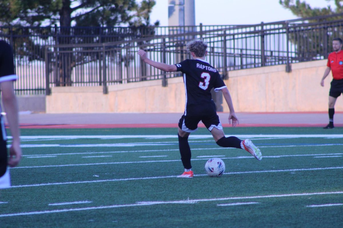 Junior Drew Tullio kicks the ball towards the goal and tries to gain his team another point.
