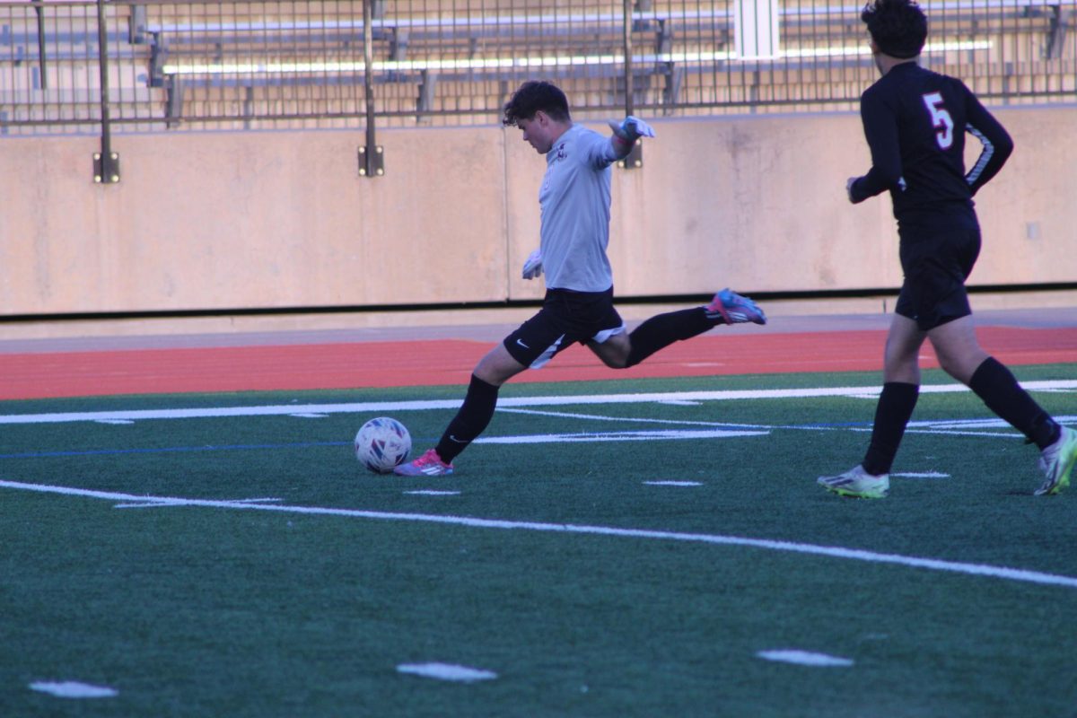 Senior Blair Nelson kicks the soccer ball out to his team mates in the hope of helping them score a goal.