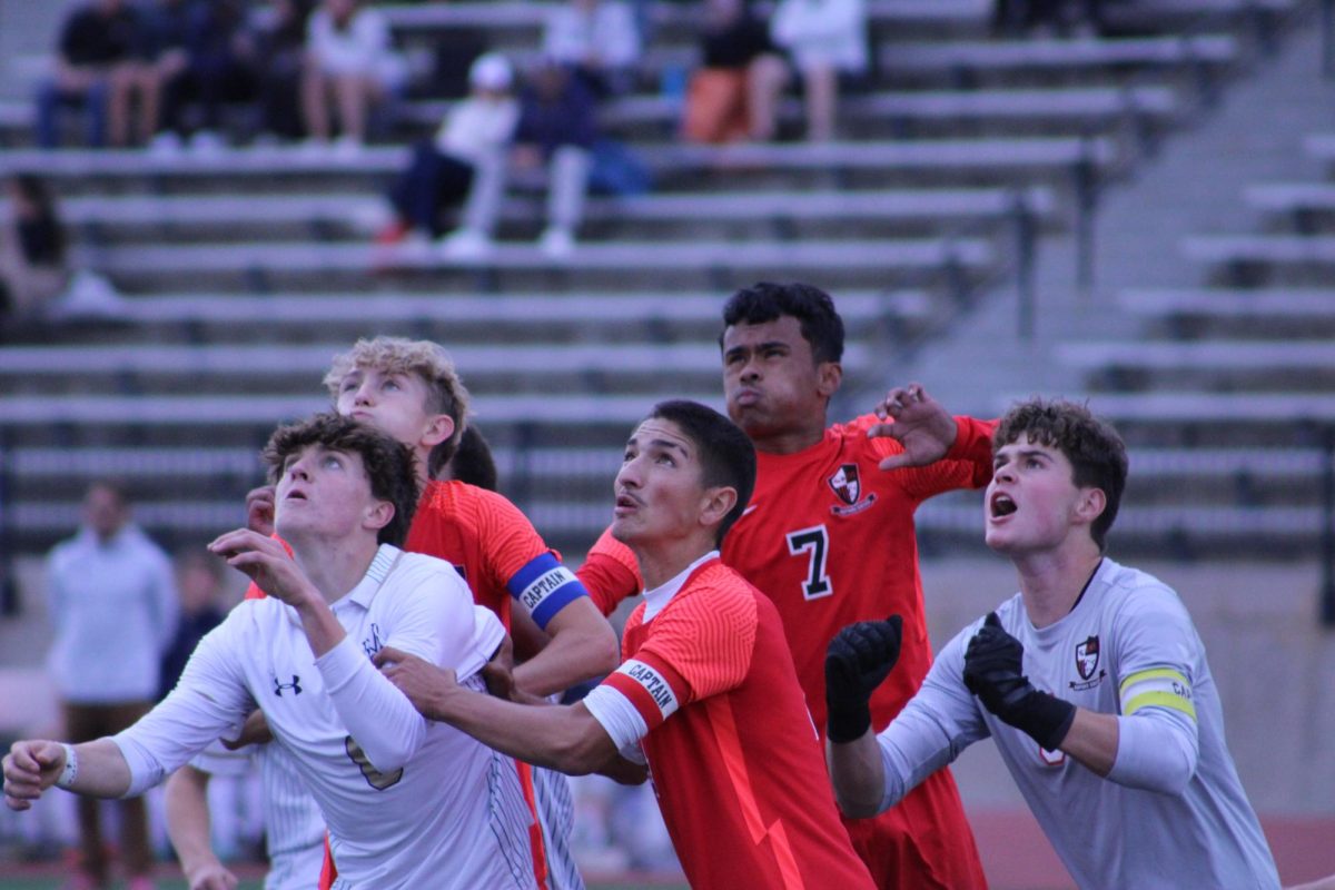 Eaglecrest players jumping to keep the ball out of the goal.