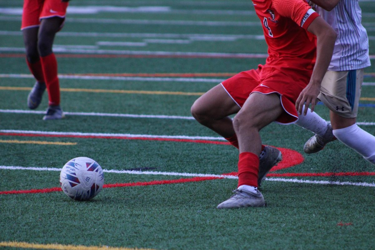 Senior Roman Yoder approaching the ball while fending off a Mullen player. 