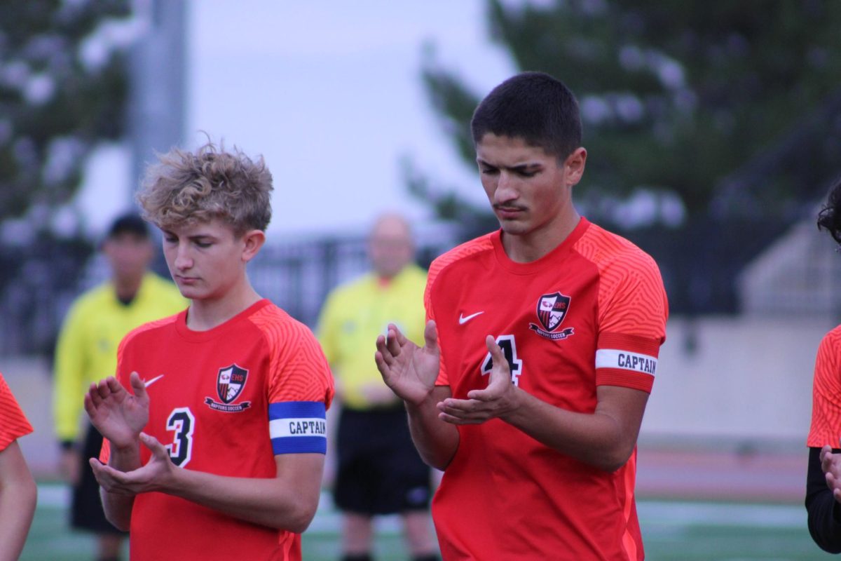 Junior Drew Tullio and senior Roman Yoder clapping as their other teammates are being announced.