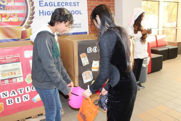 Junior Dika Sandita is passing out candy to a student and their younger sibling at our very own Fall Fest!