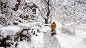 A Colorado resident clears  the sidewalk during the massive snowstorm (The New York Times)