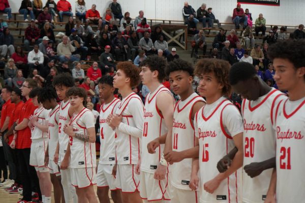 The varsity boys basketball team lining up for the national anthem.